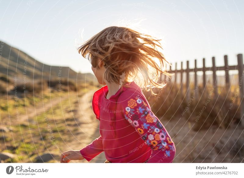 Little girl running through the Spanish landscape, Rambla del Playazo, Cabo de Gata - Nijar Natural Park, Spain national park Andalusia Iberian