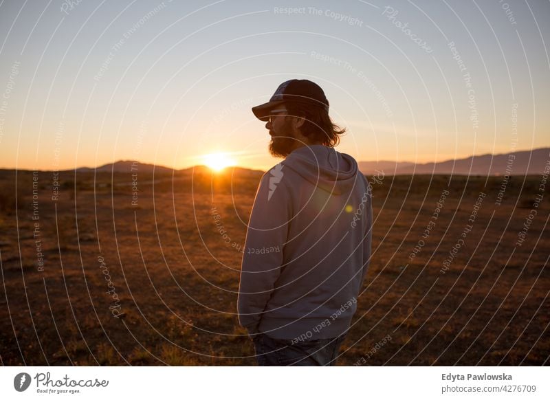 Man in a pristine landscape during a beautiful blazing sunset, Andalusia, Spain people young standing man tourist solitude alone trekking hike freedom adventure