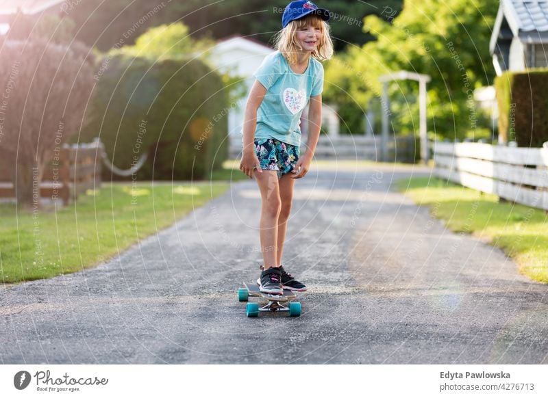 Little girl skateboarding in campsite, Texel, Holland sea camping family people girls children kids Dutch Europe Netherlands Outdoor summer day park active fun