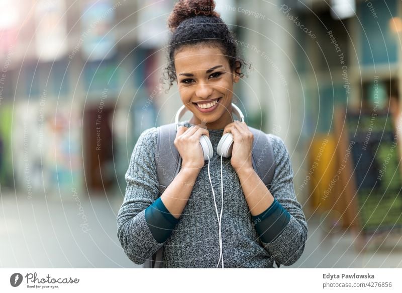 Young woman wearing headphones outdoors day positivity confident carefree people young young adult casual beautiful attractive female one person smiling happy