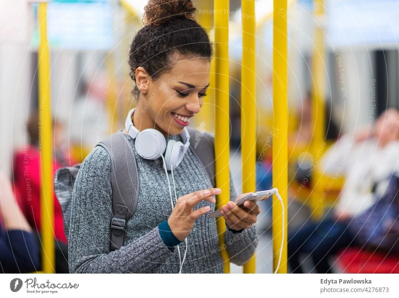 Young woman using mobile phone on subway outdoors day positivity confident carefree people young young adult casual beautiful attractive female one person