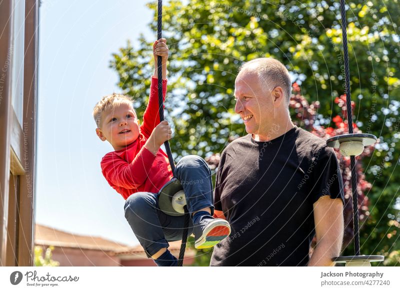 Father playing with his 3 years old son on the playground fun father kid toddler children kids portrait nature laughing bonding togetherness parenthood