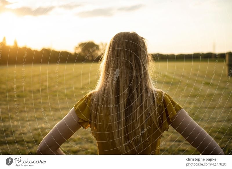 Woman looking at field in evening light Blonde To go for a walk Field Evening Evening sun Agriculture plants Grain Agricultural crop Plant Growth Summer