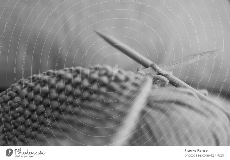 Close-up of a knitted piece with wooden knitting needles and ball of wool Knit wooden needles Ball of wool Knitting needles hobby free time Meditation Process