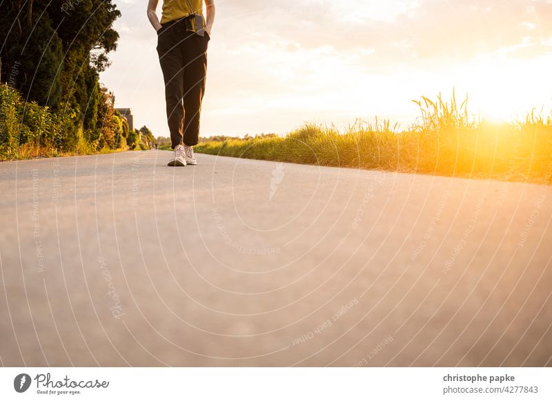 woman walking in the evening on field, low sun Woman To go for a walk Field Evening Sun off the beaten track evening light Summer stroll Going Lanes & trails