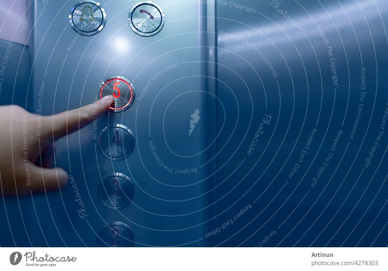 Person pressing on the fifth floor of elevator button. Hand press number 5 on button inside office or hotel lift. Index finger press on lift button. Claustrophobia. People stuck in lift. Braille code.