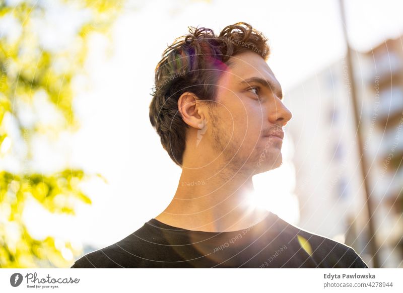 Portrait of a handsome young man in the city sunny outside curly hair hipster person adult confidence outdoors summer male attractive natural one portrait