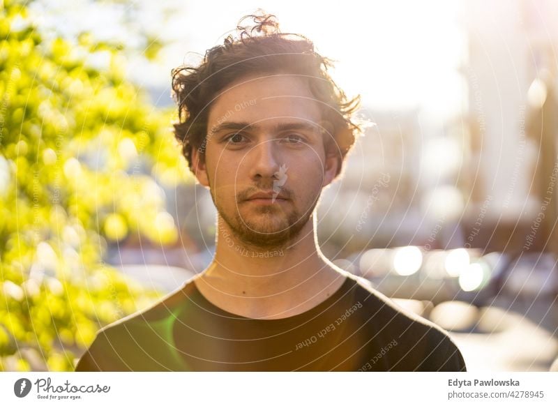 Portrait of a handsome young man in the city sunny outside curly hair hipster person adult confidence outdoors summer male attractive natural one portrait