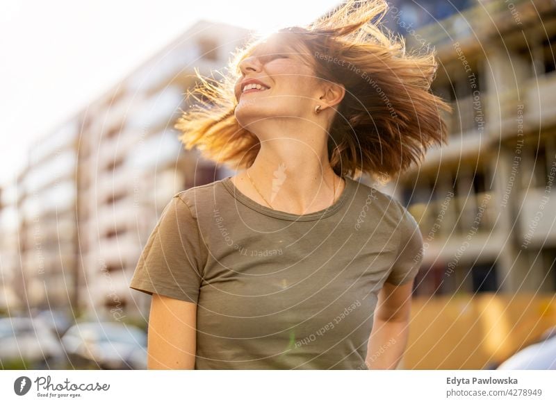 Portrait of smiling redheaded woman in the city park nature green spring red hair sunny outside pretty girl person adult confidence outdoors summer beauty