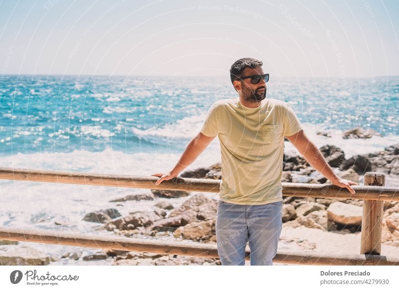 man enjoying a sunny day on the coast adult attractive beach beard blue boats boy brunet caucasian cute enjoyment face fun guy handsome happy lifestyle looking