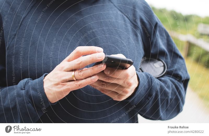 Close-up of a man with a coffee mug under his arm, busy with a black smartphone mobile work hands Cellphone Technology Telephone Internet Hand using Lifestyle