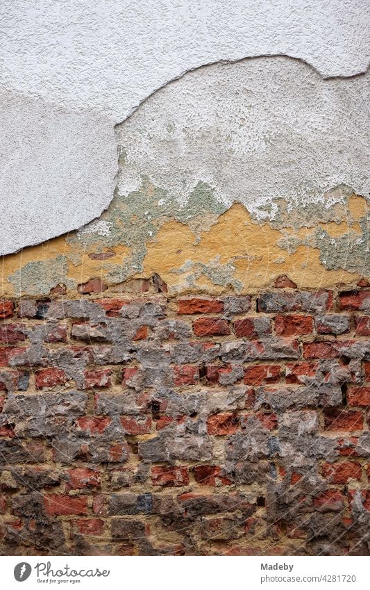 Crumbling plaster and exposed old masonry of red brick of an old building in Wettenberg Krofdorf-Gleiberg near Giessen in Hesse Wall (building) Facade