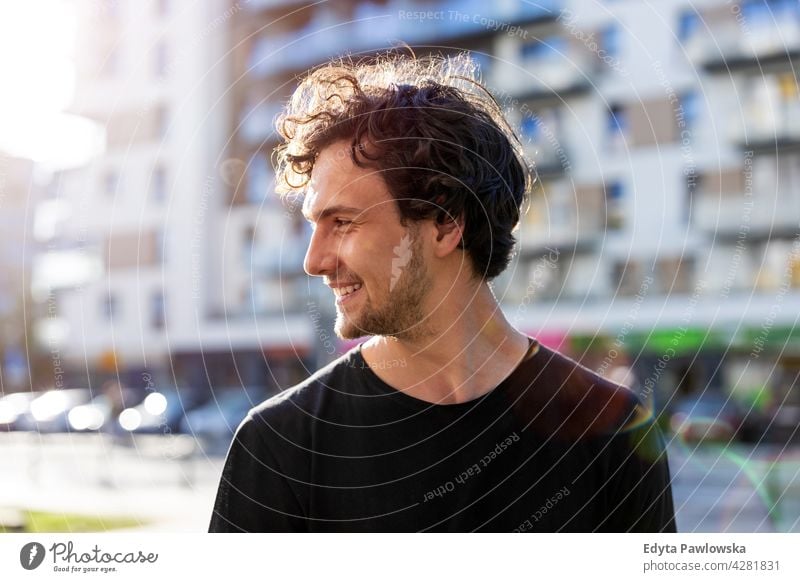 Portrait of a handsome young man in the city sunny outside curly hair hipster person adult confidence outdoors summer male attractive natural one portrait