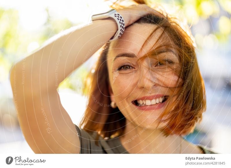 Portrait of a beautiful happy woman outdoors park nature green spring red hair redhead sunny outside pretty girl person adult confidence summer beauty female