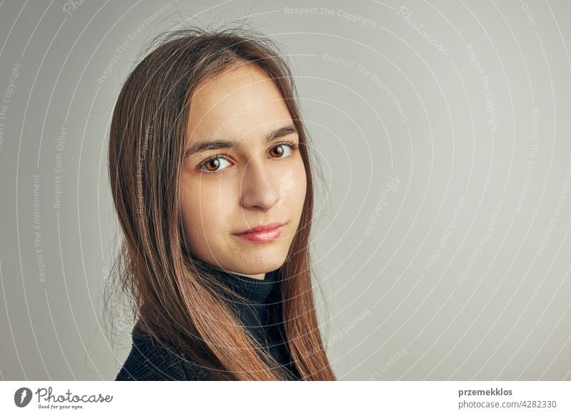 Portrait of young woman. Classic portrait in positive mood, beautiful model posing in studio over plain background headshot person female teenager pretty lady