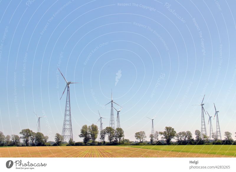 many lattice mast wind turbines stand in the landscape against a blue sky Wind energy plant Pinwheel Power Generation Energy Energy generation Renewable energy