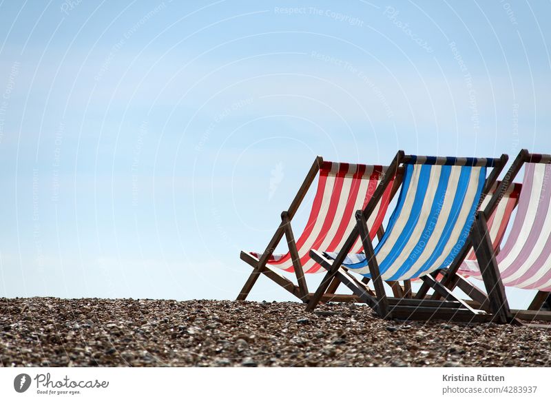 striped deck chairs on the beach, facing the sky deckchairs Folding chairs Beach Pebble beach Gravel Striped Summer Sun sunny Sky vacation holidays Relaxation