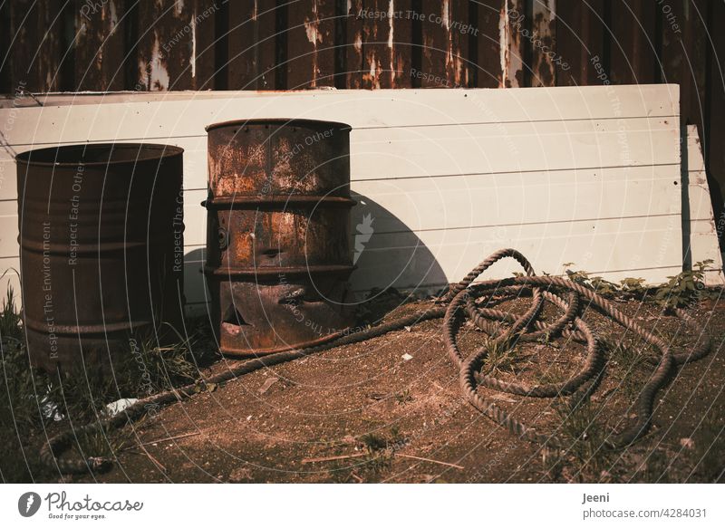 Broken rusty metal barrels and a rope lying around Metal bin ton Keg Barrels corroded Old holes holey Backyard Industry Scrap metal Scrapyard Rope Dew