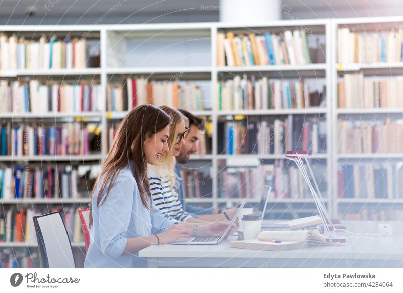 College students in a library enjoying lifestyle young adult people casual caucasian positive happy smiling woman female attractive beautiful bookstore reading