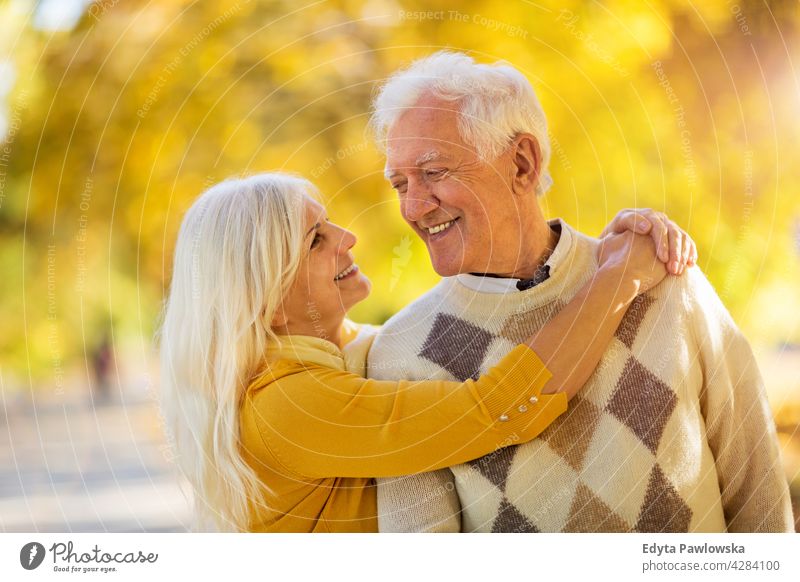 Elderly couple embracing in autumn park family woman love people outdoors portrait together nature two beautiful fall trees yellow senior mature seniors