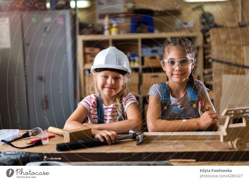 Two young girls doing woodwork in a workshop working people child children kid kids girl power Skill craft Garage Hobby Lifestyle tools Concentration Creativity