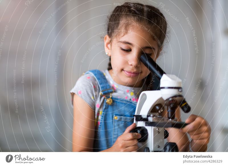 Young girl looking through microscope science workshop learning people child children kid kids Skill Lifestyle Concentration Caucasian Childhood desk Education