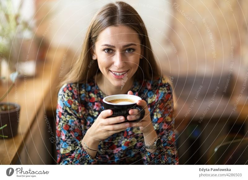 Young woman with cup of coffee people young adult casual attractive female smiling happy Caucasian toothy enjoying one person beautiful portrait positivity