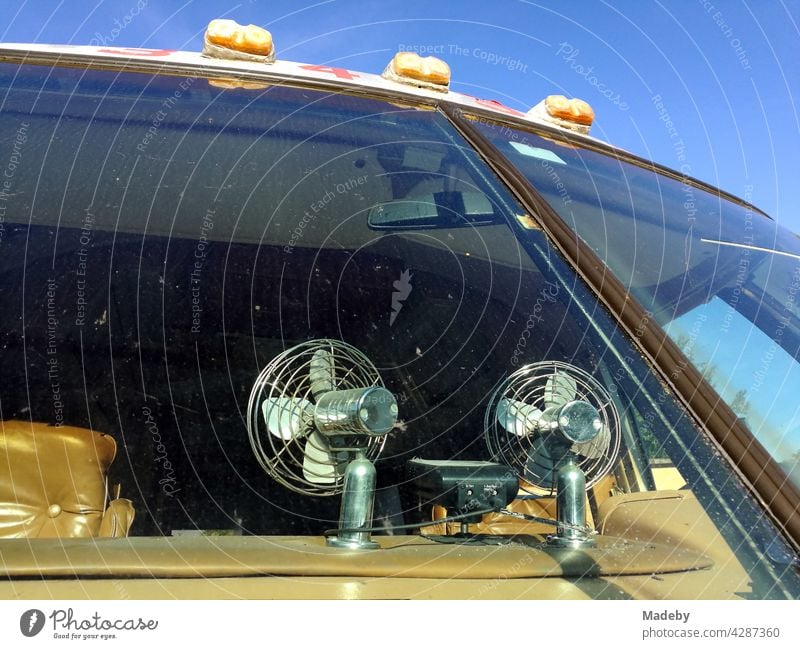 Fans on the dashboard of a classic american camper van of the luxury class in front of a blue sky at sunshine in Detmold in East Westphalia-Lippe, Germany.