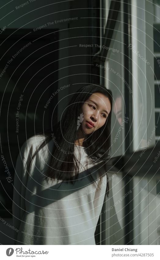 Girl Thinking Near The Window window portrait mood moody Mood lighting moody atmosphere Interior shot Moody moody weather thinking waiting young teen asian joy