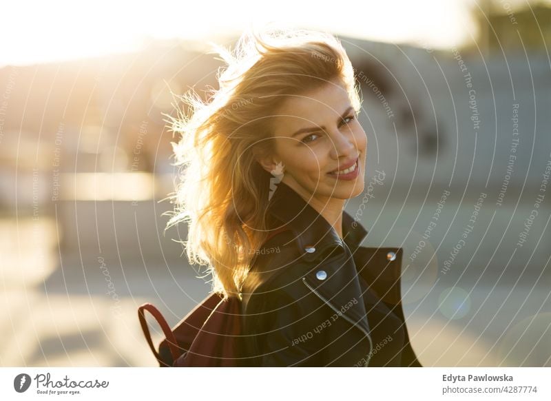 Young woman in the city at sunset enjoying lifestyle young adult people casual caucasian positive happy smiling female attractive beautiful day outdoors urban