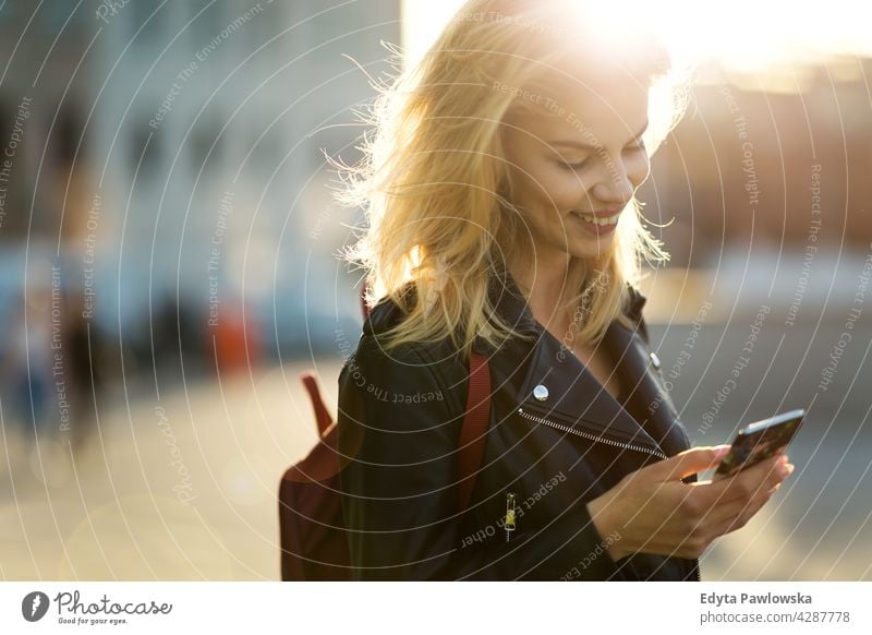 Young woman in the city at sunset enjoying lifestyle young adult people casual caucasian positive happy smiling female attractive beautiful day outdoors urban