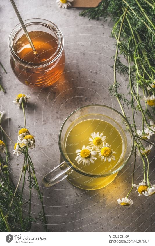 Honey and fresh brewed tea with organic herbs on dark concrete background. Natural treatment. Top view honey natural autumn theme top view copy space product