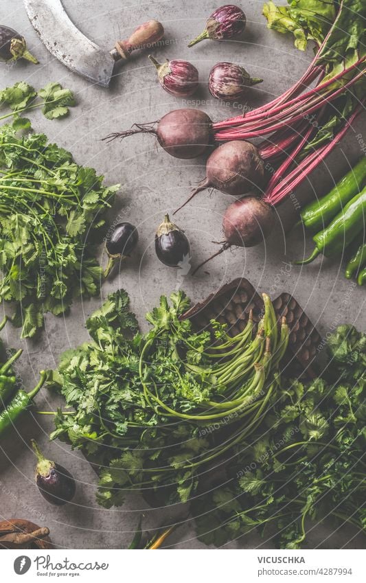 Fresh bundle of beetroot and herbs. Vegetables and vintage kitchen utensils on dark concrete background. Cooking preparation with fresh vegetables. Healthy food concept. Top view