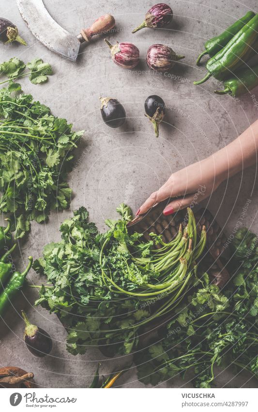 Woman hands holding vintage bowl with fresh herbs. Healthy cooking preparation. Top view kitchen woman box concrete dark background ingredients like vegetables