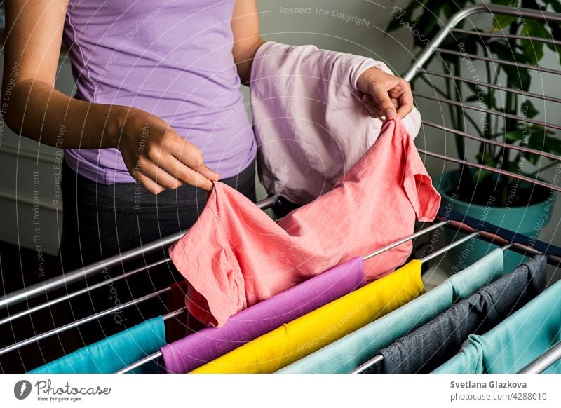 Laundry day Rainbow color clothes hanging on washing line to dry indoors home laundry clean household rainbow clothing housework cotton fresh textile domestic