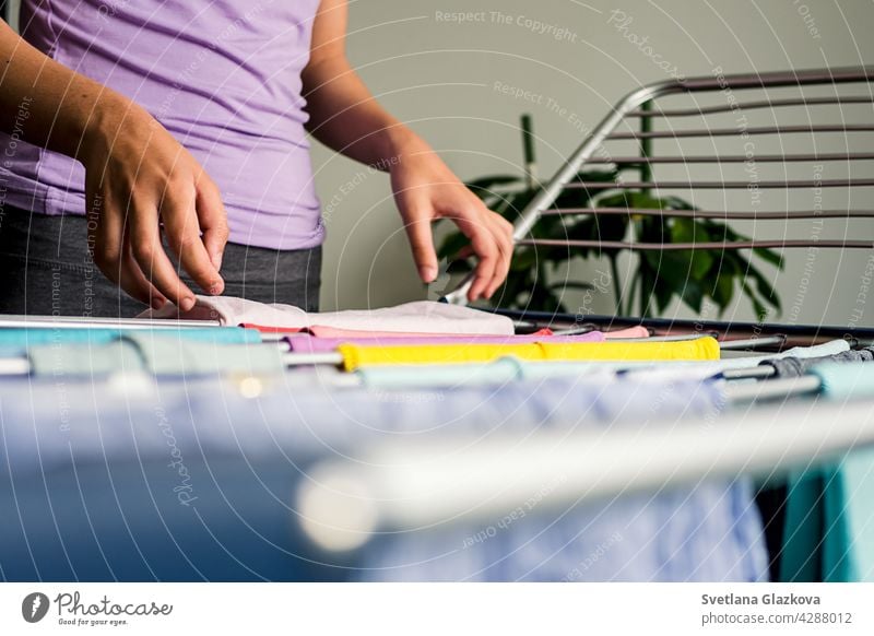 Laundry day Rainbow color clothes hanging on washing line to dry indoors home laundry clean household rainbow clothing housework cotton fresh textile domestic