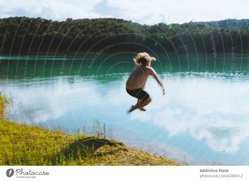 Man having fun on lake man jump reflection water summer forest landscape mountain nature beautiful tranquil blue serene green scene spring europe tree scenery