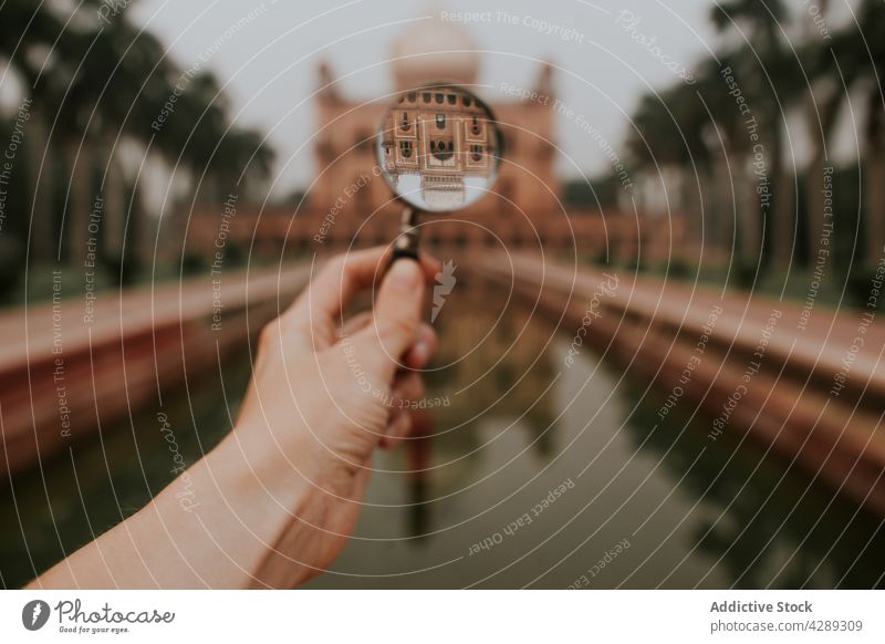 Tourist with magnifier against aged building person tourist heritage mausoleum landmark culture history attract medieval travel traveler old vacation trip