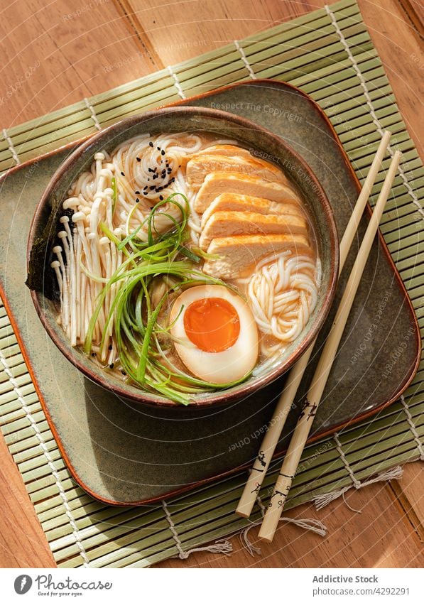 Chicken ramen soup in a bowl with chopsticks cuisine savory meat green onion asia homemade miso marinated japanese food table bright udon spice noodles