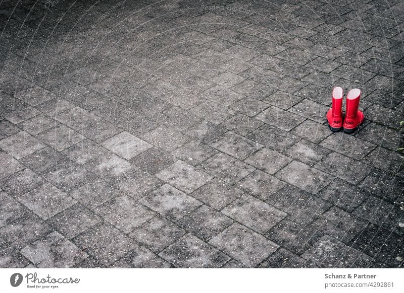 red rubber boots on stone floor Rubber boots Red Paving stone Stone floor Children's shoes Playing feet out sealed Gray Exterior shot Colour photo Deserted