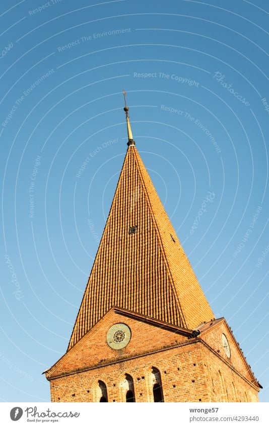 2 sides of the Schwaan church spire under a cloudless blue sky Church spire Church tower clock rare watch Cloudless sky Blue sky Sky Exterior shot