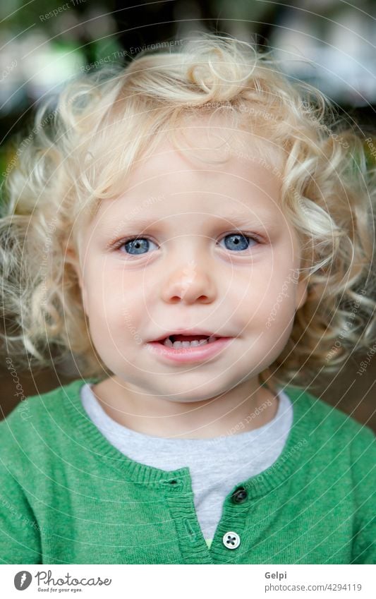 Little baby boy with curl hair and blue eyes child kid childhood toddler snug little white outdoors small fashion vibrant clothing shy shyness standing