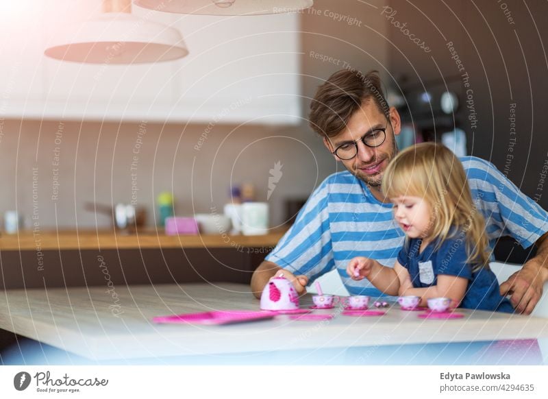 Father and daughter having a tea party at home house man dad father family parent relatives child girl little girl kid kids children relationship together