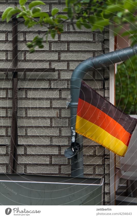 Germany flag in the allotment garden Evening Garden Garden allotments Deserted tranquillity Holiday season Garden plot Copy Space Flag German flag Nationality