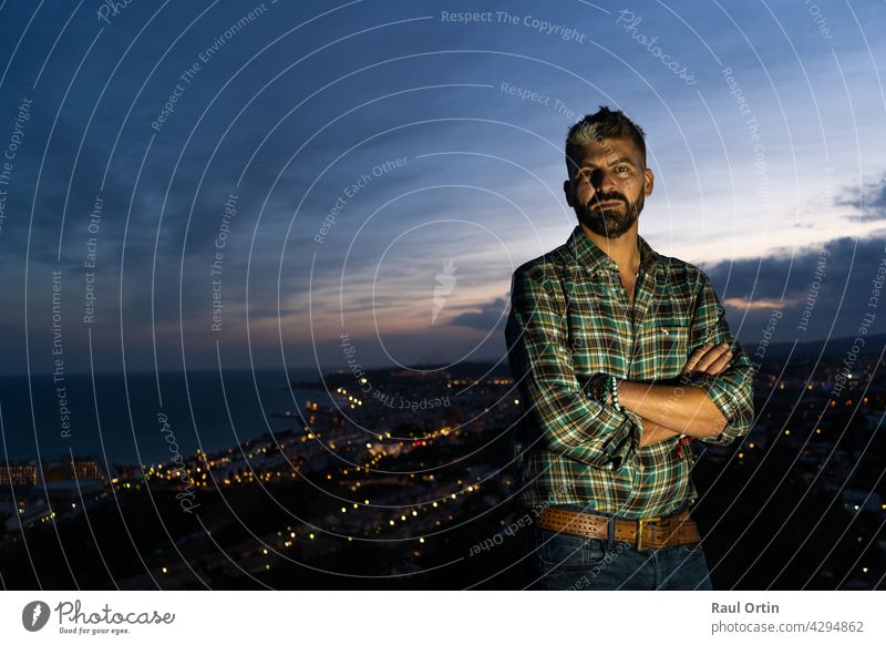 Amazing night coast village landscape with a male standing with crossing arms person silhouette man nature background alone adventure sky beautiful travel