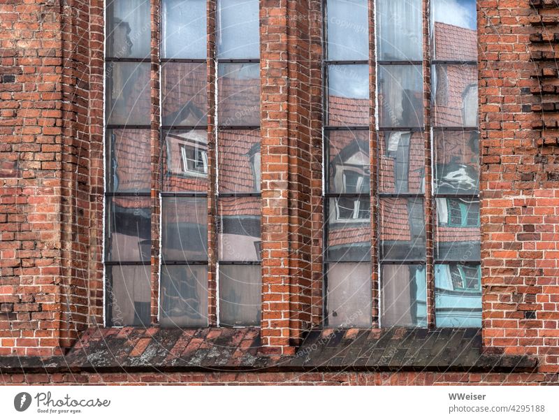 The colourful little houses of the old town are reflected in the windows of the old church Church Brick brick Old refurbished Old town Downtown atmospheric