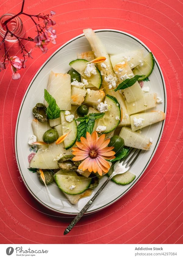 Melon salad with cucumbers and olives healthy food diet vegan serve table melon herb napkin salt shaker plate organic appetizer delicious dish portion nutrition