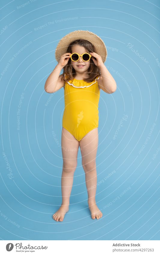 Stylish little girl in summer outfit style yellow fashion happy smile kid sunglasses beach child cute bright cheerful trendy carefree straw hat color cool