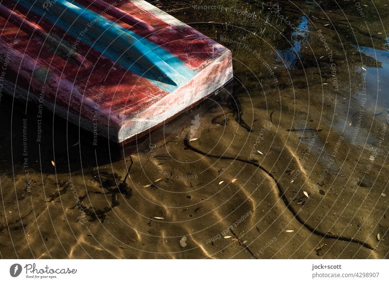 Boat put down + turned over boat Surface of water Shadow Sunlight Nature Lake bank reflection Water Calm Idyll Rope worn-out Plastic Bleached Lakeside Peaceful