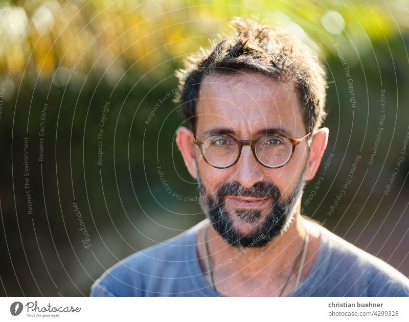 man portrait with glasses Man Eyeglasses Facial hair 50 years Sun Nature Green kind Light mediative eyes bokeh Interesting Model Advertising